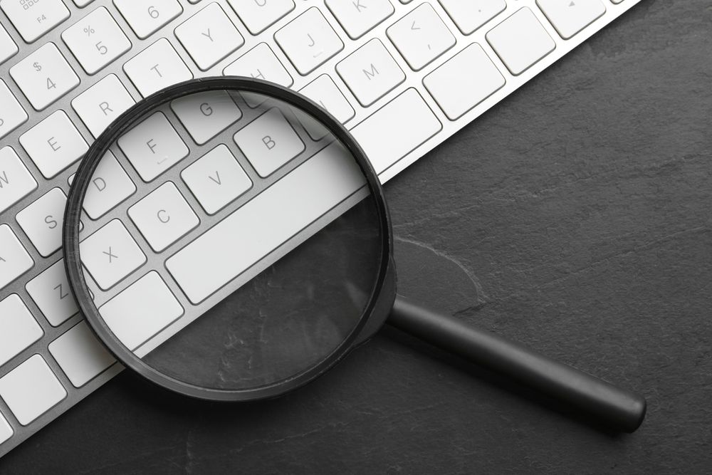 Magnifying glass on a keyboard to represent targeted searches with Local SEO.